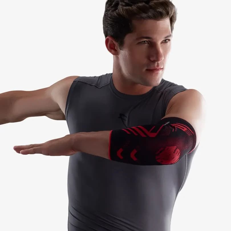 Man in a grey training top wearing a black and red Vissco PRO elbow sleeve
